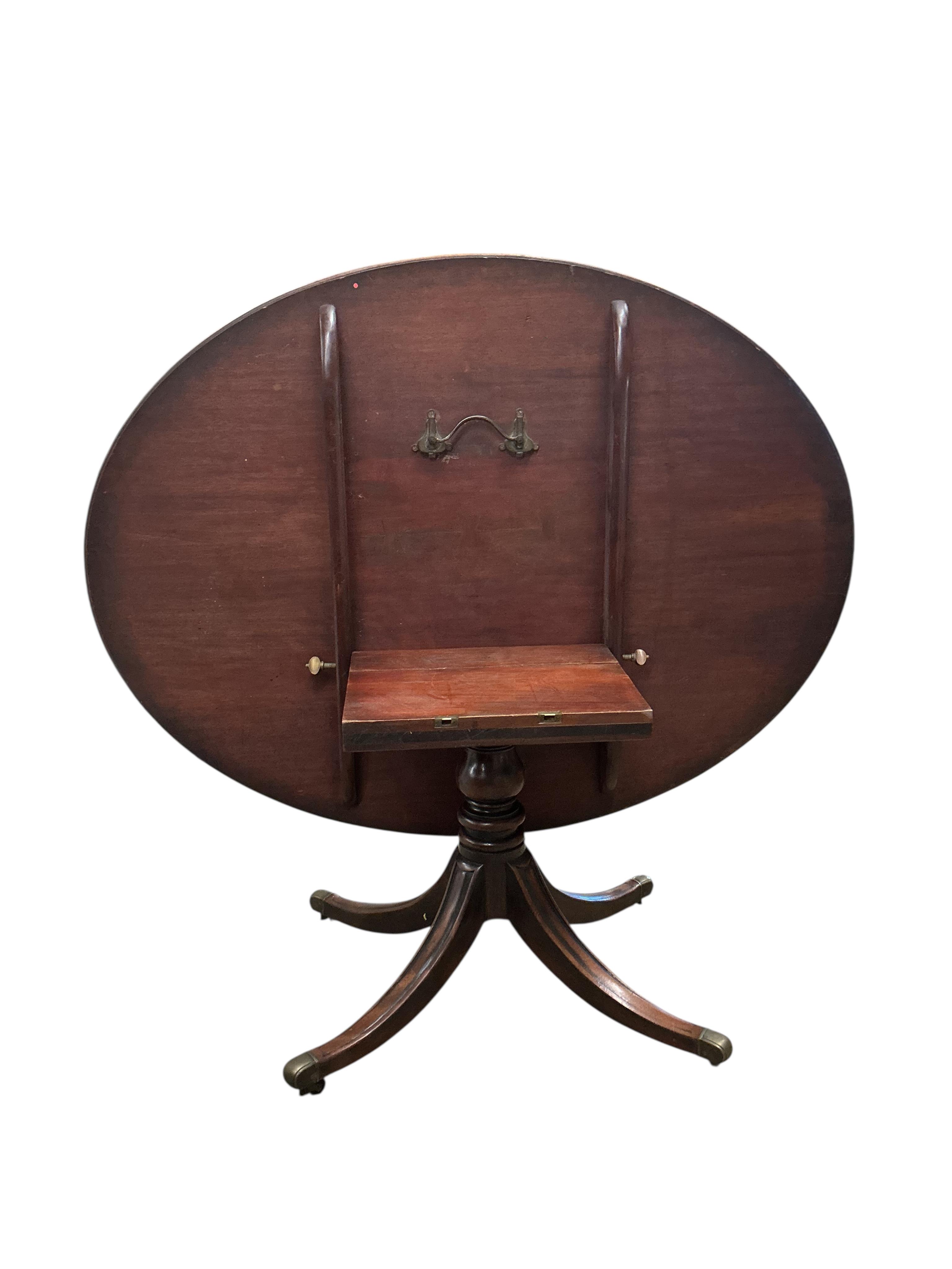 A George III banded mahogany oval tilt top dining table, width 160cm, depth 122cm, height 70cm